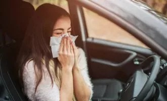 woman-driver-blowing-nose-with-handkerchief